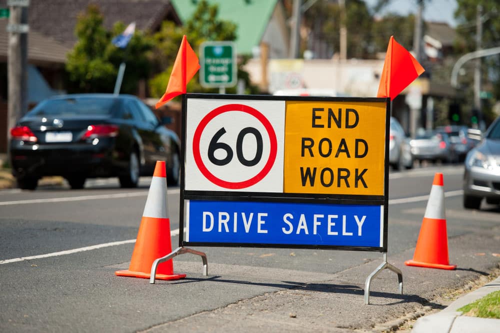 Temporary 60 km/h end roadworks sign with traffic cones