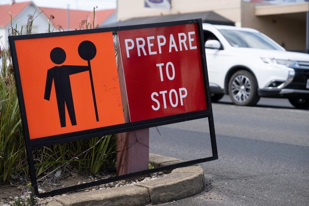Temporary prepare to stop roadworks sign beside passing traffic
