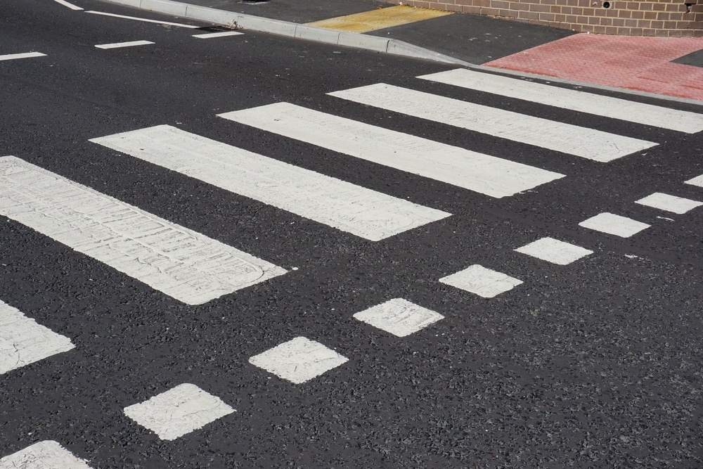 White pedestrian crossing markings on an asphalt road