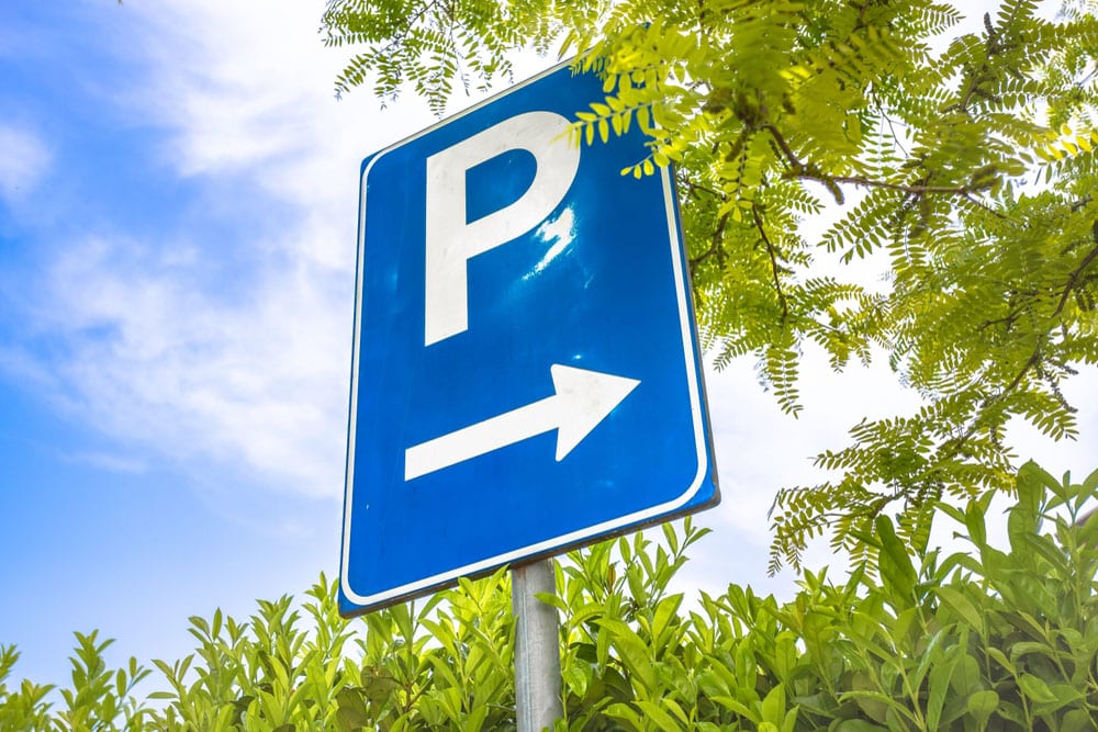 Blue parking direction sign installed on a roadside post